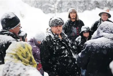  ?? CHAD HIPOLITO / THE CANADIAN PRESS ?? Chief Madeek, hereditary leader of the Gidimt’en clan, talks with supporters of the Unist’ot’en camp and Wet’suwet’en people near a checkpoint camp fire off a logging near Houston, B.C., on Wednesday.