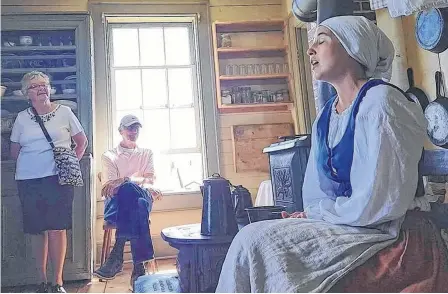  ?? CONTRIBUTE­D ?? Amber Buchanan sings to visitors at the Highland Village Museum in this photo taken last year. Buchanan and other staff at the 40-acre outdoor living history site have been sharing videos to help people learn Gaelic by doing the dishes, taking a short walk, or looking at colours of wool on a loom.