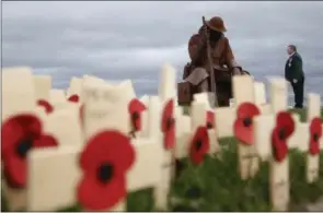  ?? OWEN HUMPHREYS / PA VIA AP ?? Larry Roberts, 60, a veteran from South Shields in England, who served with the Royal Green Jackets, stands for a moment looking at the sculpture entitled Eleven ‘O’ One in Seaham, County Durham, England, ahead of playing the bugle during a ceremony to mark Armistice Day, the anniversar­y of the end of the First World War, Wednesday Nov. 11, 2015. The statue of the WWI soldier, built out of special corteen steel, nicknamed ‘Tommy’ by locals was installed to mark the centenary of the start of the Great War.