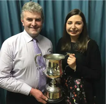  ??  ?? Muireann Vaughan receiving the winner’s trophy from Jerry Doody after her success in Solo Singing at the Munster Scor Sinsear finals last weekend.