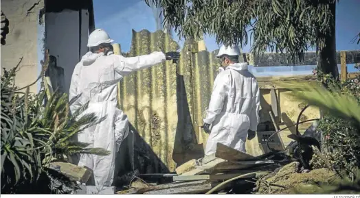  ?? JULIO GONZÁLEZ ?? Operarios retiran amianto entre los residuos provinient­es del derribo de las casetas de la playa de La Casería de San Fernando.