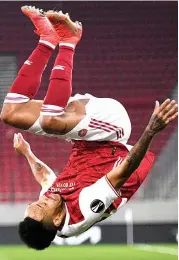  ?? — AP ?? Pierre-Emerick Aubameyang of Arsenal celebrates after scoring his side’s third goal against Benfica during their Europa League Round of 32 match at Georgios Karaiskaki­s stadium in Piraeus port near Athens on Thursday. Arsenal won the match 3-2.