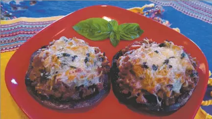  ?? LUCY HERRMAN/For the Taos News ?? Portobello mushrooms with an easy homemade sausage and tomato sauce, sprinkled with herbs and cheese.