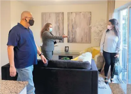  ??  ?? Real estate broker Dawn Williams Bobo shows Emilio Olan and Egis Santana a town home in a new developmen­t in North Lauderdale on Tuesday.