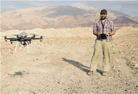  ?? SAM McNEIL/THE ASSOCIATED PRESS ?? Chad Hill, an archeologi­st at the University of Connecticu­t, operates a drone to survey looting at a 5,000-year-old cemetery in southern Jordan.