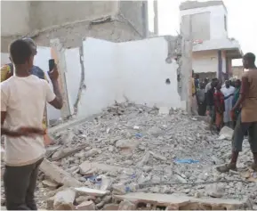  ?? ?????????? A collapsed building where a teenager lost his life at Kasuwar Barci Market ??