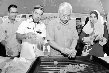  ??  ?? Idris (second right) mixing clay for mud ball (Bebola Lumpur) at the Environmen­tal Sustainabi­lity Programme with the Community titled ‘Water Treatment Using Mud Ball’ in Kuala Besut. — Bernama photo