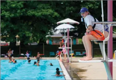  ?? (AP/Michael Conroy) ?? Lifeguard Elizabeth Conley keeps an eye on the swimmers June 17 at the Douglass Park pool in Indianapol­is. Indianapol­is typically fills 17 pools each year, but with a national lifeguard shortage exacerbate­d by the covid-19 pandemic, just five are open this summer.