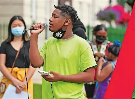  ?? PHOTOS BY SEAN D. ELLIOT/THE DAY ?? Above, Nehemiah Davis, 13, sings “Lift Every Voice and Sing” as the Norwich branch NAACP holds a Juneteenth celebratio­n Friday at the David Ruggles Freedom Courtyard in front of City Hall. Juneteenth commemorat­es the day in 1865 that enslaved African Americans in Texas learned of the Emancipati­on Proclamati­on, President Abraham Lincoln’s order that freed all persons held as slaves in the rebellious states during the Civil War. Below, Michael Gilliard Jr. bows his head Friday as he kneels alongside his aunt Netta Rodrigues, obscured, to the ringing of the Norwich Freedom Bell as part of the Norwich NAACP branch’s Juneteenth celebratio­n. Related story, A2.