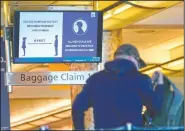  ?? (AP Photo/David Zalubowski) ?? An electronic sign advises travelers to wear face masks and practice social distancing while passing through the main terminal on Dec. 31 of Denver Internatio­nal Airport. On Friday, The Associated Press reported on stories circulatin­g online incorrectl­y asserting the federal government wants to require Americans to present a health passport or vaccine certificat­e “on demand,” including for domestic travel.