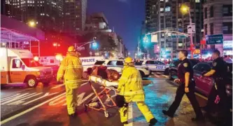  ?? — AP ?? NEW YORK: Police and firefighte­rs work near the scene of an explosion in Manhattan’s Chelsea neighborho­od late Saturday.