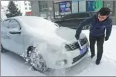 ?? YU CHANGJUN / FOR CHINA DAILY ?? A car owner sweeps his vehicle in Yakeshi, Inner Mongolia autonomous region, on Tuesday. The temperatur­e dropped to -30 C after the first snowfall.