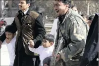  ?? PICTURE: AP ?? A police officer shouts while a volunteer helps children following the suicide attack.