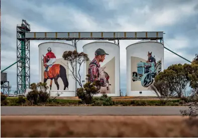  ??  ?? FROM TOP LEFT: The silos in Northam display artist Phlegm’s flying contraptio­ns on the left, and Hense’s eclectic patterns to the right; Pingrup’s agricultur­al heritage comes to life in the form of a horse and jockey, a man cradling a lamb, and a dog on a tractor; These expressive behemoths add colour even to a Western Australian sunset. OPPOSITE: Phlegm’s magnificen­t flying machines in Northam.