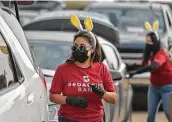  ?? Robin Jerstad / Contributo­r ?? Lisa Gomez joins other volunteers in loading cars and spreading Easter joy on Friday.