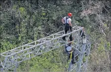  ?? [RAMON ESPINOSA/THE ASSOCIATED PRESS] ?? Workers for Whitefish Energy repair a power line in Barcelonet­a, Puerto Rico, damaged by Hurricane Maria in September.