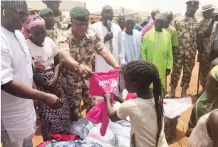  ?? Photo: Lami Sadiq ?? Operation Safe Haven Commander, Major General Augustine Agundu, donates clothes to people of Nandu who lost their homes after an attack on the village in Sanga Local Government Area of Kaduna State last weekend.