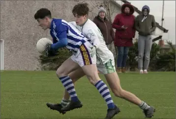  ??  ?? A.J. Redmond of Good Counsel is wrapped up by his Minor hurling colleague from last year, Justin Moran.