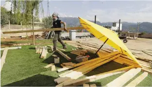  ?? —AFP photos ?? Lebanese architect Roy Dagher builds a wooden structure on the rooftop of his building, during a lockdown imposed by the authoritie­s in a bid to stem the spread of the novel coronaviru­s in the village of Fatri, north of the capital Beirut.