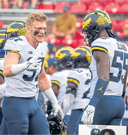  ?? ?? Aidan Hutchinson greets team-mate linebacker David Ojabo.