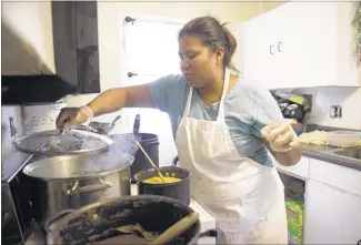  ?? BRANDON DILL/SPECIAL TO THE COMMERCIAL APPEAL ?? Eneydi Lopez checks on a pot of steaming tamales at her home. Lopez sells tamales each weekend at the Cooper Young Farmers Market. She will lead one of the teams competing in the annual Centro Cultural Tamale Fest at Caritas Village on Saturday.