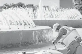  ?? Brett Coomer / Houston Chronicle ?? Conservati­onists say the addition of limestone at the base of Mecom Fountain, which was built in 1964, diminishes its historic nature. Workers this week have been adding the limestone slabs, which will match new planters nearby.