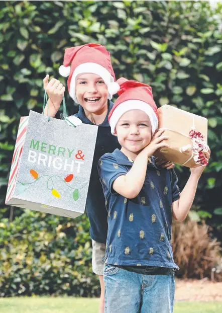  ?? Picture: GLENN HAMPSON ?? Hayden and Jack Armstrong from Pacific Pines collecting presents to give to children in foster care.