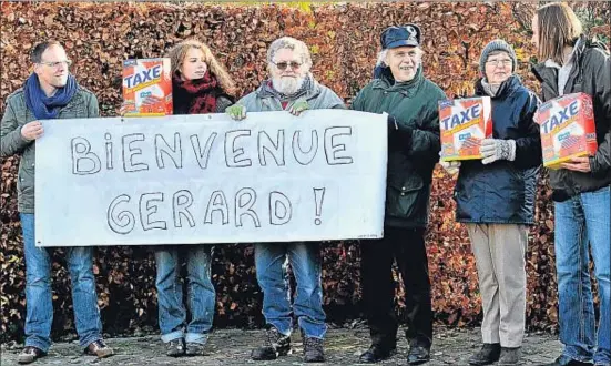  ?? PHILIPPE HUGUEN / AFP ?? Militants del Partit dels Treballado­rs Belgues donant la benvinguda a Gérard Depardieu davant la casa adquirida per l’actor a Néchin