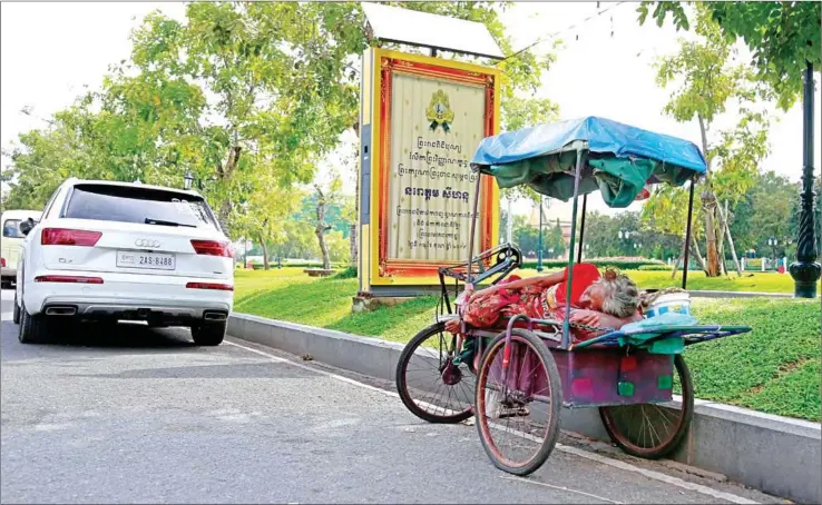  ?? HENG CHIVOAN ?? An elderly woman takes an afternoon nap on her three-wheeled cart in Phnom Penh on Wednesday.