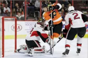  ?? MATT SLOCUM — THE ASSOCIATED PRESS ?? Philadelph­ia Flyers forward Travis Konecny leaps between Ottawa Senators’ Craig Anderson (41) and Dion Phaneuf (2) during the second period Tuesday.