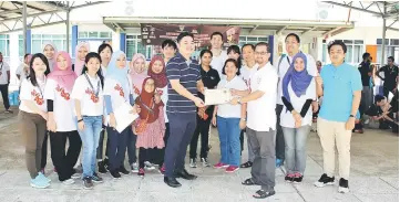  ??  ?? Dr Ong (right, front) handing over the certificat­es of participat­ion to the volunteers.