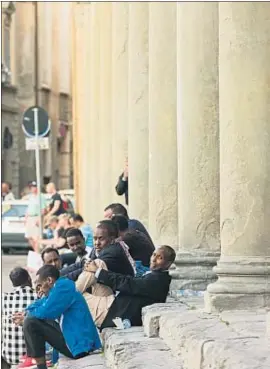  ?? PETER PTSCHELINZ­EW / GETTY ?? Un grup d’immigrants s’aplega en una plaça de Florència
