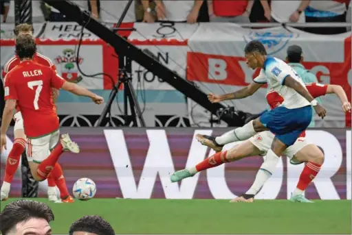  ?? (AFP) ?? England’s forward Marcus Rashford scores his team’s third goal during the FIFA World Cup Qatar 2022 Group B match against Wales at the Ahmad Bin Ali Stadium on Tuesday night.