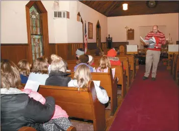  ?? Donnis Hueftle-Bullock ?? Brenner Beavers, right, leads the singing of Christmas Carols at the old Episcopal Church during Callaway’s Community Christmas Dec. 4.