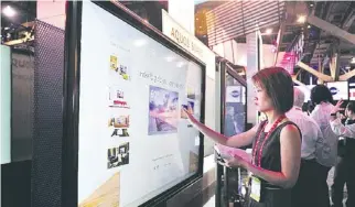  ??  ?? UNA mujer toca un televisor Sharp “touch screen” de 80 pulgadas, durante el inicio de la feria más importante de tecnología para el consumidor. A la derecha, el vicepresid­ente ejecutivo de Sony, Kazuo Hirai.