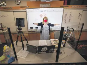  ?? Allen J. Schaben Los Angeles Times ?? LISA HICKMAN, a second- grade teacher at Sycamore Magnet Academy, has plastic dividers set up in her Tustin classroom. She’s anxious about the setup, but also excited to see her students: “They’re my babies.”