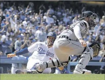  ?? Mark J. Terrill Associated Press ?? THE DODGERS’ Chris Taylor, left, scores from first on a double by Cody Bellinger as Tigers catcher Tucker Barnhart takes a late throw during the sixth. The Dodgers later added an unearned run to take a 6-0 lead.