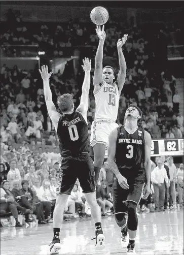  ?? Marcio Jose Sanchez Associated Press ?? KRIS WILKES shoots the winning three-point basket over Rex Pf lueger (0) and Prentiss Hubb with ninetenths of a second to play in UCLA’s 65-62 victory over Notre Dame at Pauley Pavilion. Wilkes had 14 points.