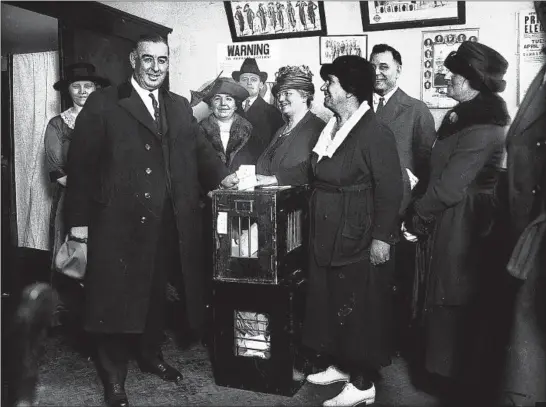  ?? CHICAGO TRIBUNE PHOTO ?? Chicago Mayor William H. Thompson, left, casts his vote, circa 1920. Thompson, a Republican, served three terms as mayor.