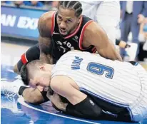  ?? STEPHEN M. DOWELL/ORLANDO SENTINEL ?? Orlando center Nikola Vucevic (9) and Toronto forward Kawhi Leonard battle for the ball during Game 3 of the teams’ first-round NBA playoff series. The seventh-seeded Magic lost in five games.