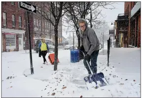  ?? AP/The Berkshire Eagle/GILLIAN JONES ?? Landscapin­g employee Zach Lusignan shovels snow Sunday from a street in Williamsto­wn, Mass. Parts of the Northeast were expecting more than a foot of snow from a deadly winter storm moving into the region.