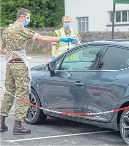  ??  ?? ARMY LIFE: main picture, The Black Watch march through Inverness in 2018 following a tour of duty in Iraq; top, a serviceman at work at a military-operated Covid testing site; and, above, soldiers control the entrance and exit to a test facility in Pitlochry.
