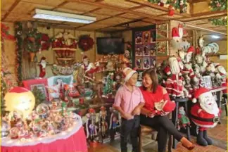  ?? Photo by Milo Brioso ?? MERRY CHRISTMAS. Santa Claus collector Susan Sanidad shares a sweet moment with her grandson, Angelo, with the collection of the Christmas icon displayed in their house.