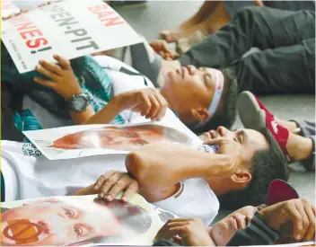  ?? PHOTO BY AP ?? DIE-IN. Scavengers Protesters stage a diein protest in front of the office of Nickel Asia, a Nickel mining company, to demand its closure.