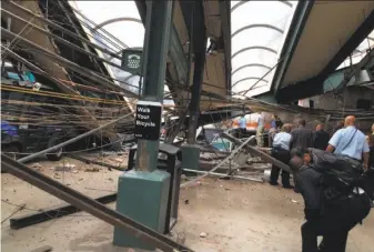  ?? William Sun / Associated Press ?? Structural damage is seen at the train station in Hoboken, N.J., after a New Jersey Transit commuter train crashed through a barrier into the station during the morning rush hour.