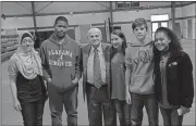  ?? Noah Syverson / Rome News-Tribune ?? Yumna Musleh (from left), Mikasha Bryant, Holocaust survivor Hershel Greenblat, Sophia Guyant, Ewan Parker, and Kiersten Cooke speak to each other in the Rome Middle gym after Greenblat finished his presentati­on.