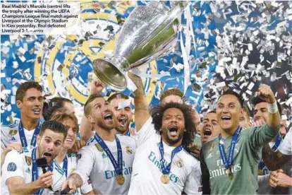  ?? AFPPIX ?? Real Madrid’s Marcelo (centre) lifts the trophy after winning the UEFA Champions League final match against Liverpool at the Olympic Stadium in Kiev yesterday. Real defeated Liverpool 3-1. –