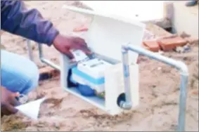  ??  ?? A consumer punches in the recharge pin number for a prepaid water meter