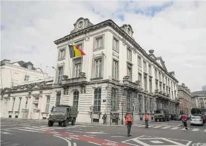  ?? JAMES ARTHUR GEKIERE/AFP/GETTY IMAGES ?? Belgian soldiers and police officers block the road outside Prime Minister Charles Michel’s office in Brussels last week. Security for Michel has been increased since twin bombings in the Belgian capital killed 32 people and three suicide bombers.