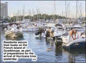  ?? AFP ?? Residents secure their boats on the French island of Guadeloupe, as part of preparatio­ns for the arrival of Hurricane Irma yesterday.